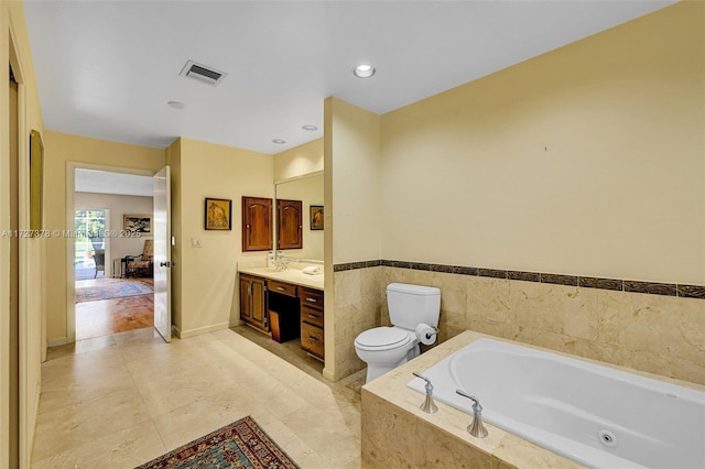 bathroom with tiled bath, toilet, and vanity