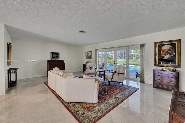 living room featuring a textured ceiling and french doors