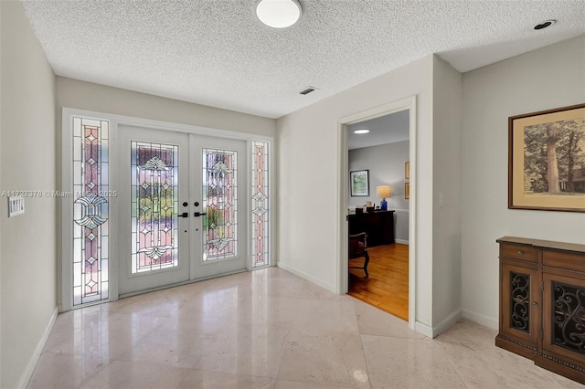 entrance foyer with french doors and a textured ceiling