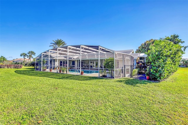 rear view of house featuring glass enclosure and a lawn