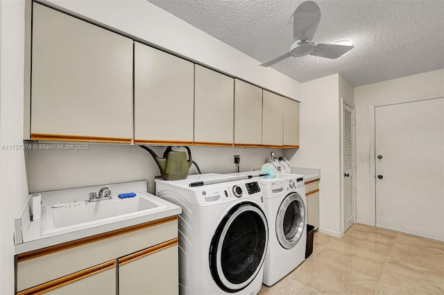 clothes washing area with ceiling fan, independent washer and dryer, sink, a textured ceiling, and cabinets