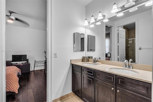 bathroom with ceiling fan, vanity, a shower with door, and hardwood / wood-style flooring