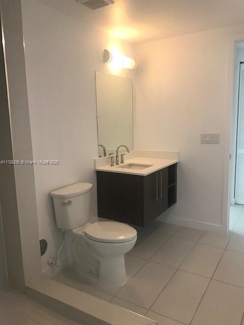 bathroom with tile patterned floors, vanity, and toilet