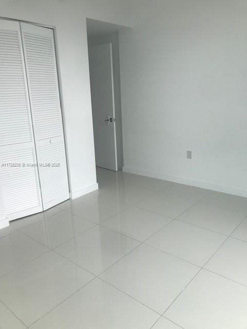 unfurnished bedroom featuring tile patterned flooring and a closet