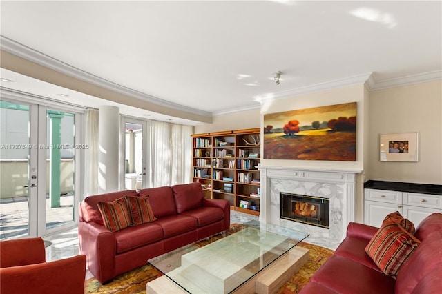 living room with a premium fireplace, ornamental molding, and french doors