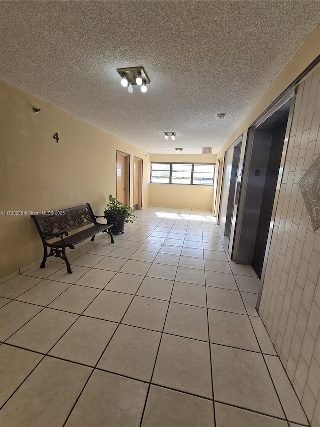 hallway featuring light tile patterned floors and a textured ceiling