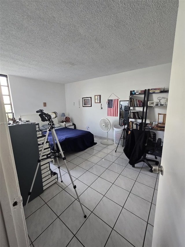 bedroom featuring light tile patterned floors and a textured ceiling