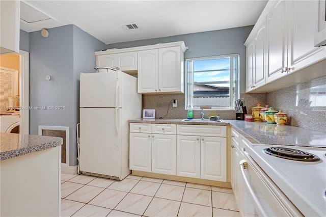 kitchen featuring white appliances, washer / dryer, white cabinetry, decorative backsplash, and sink