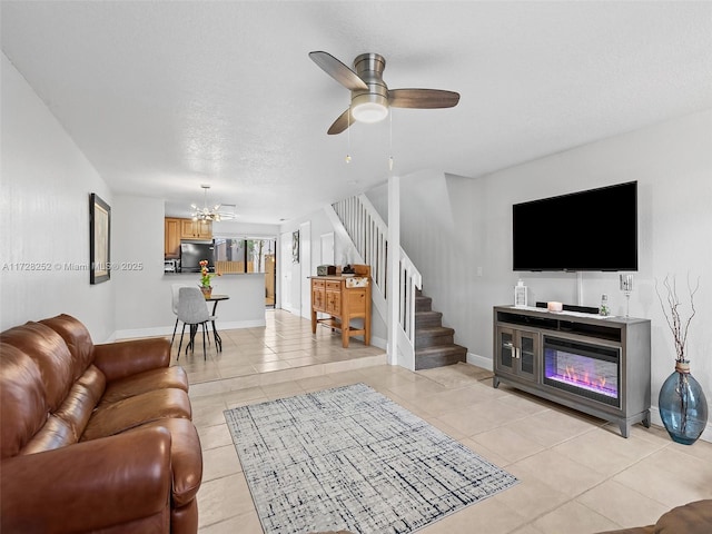 living room with light tile patterned floors and ceiling fan with notable chandelier