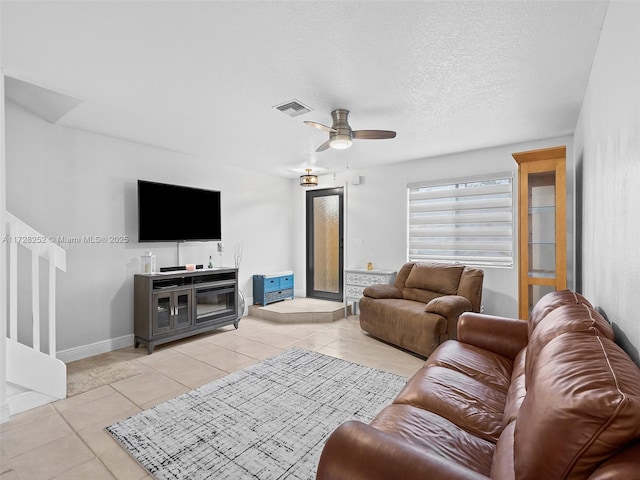 tiled living room with a textured ceiling and ceiling fan