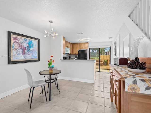 dining room featuring a textured ceiling, a chandelier, and light tile patterned flooring