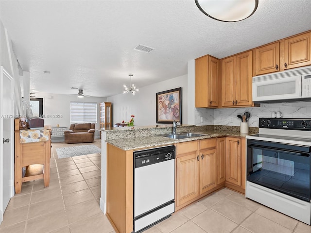 kitchen featuring light tile patterned floors, kitchen peninsula, sink, and white appliances