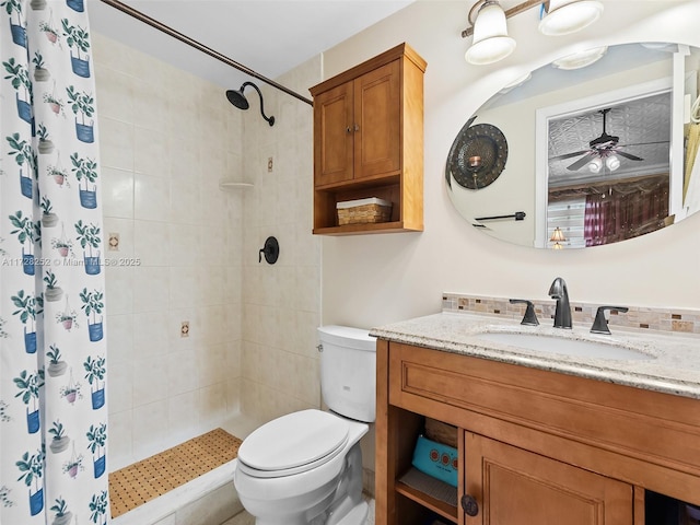 bathroom featuring toilet, ceiling fan, vanity, and curtained shower