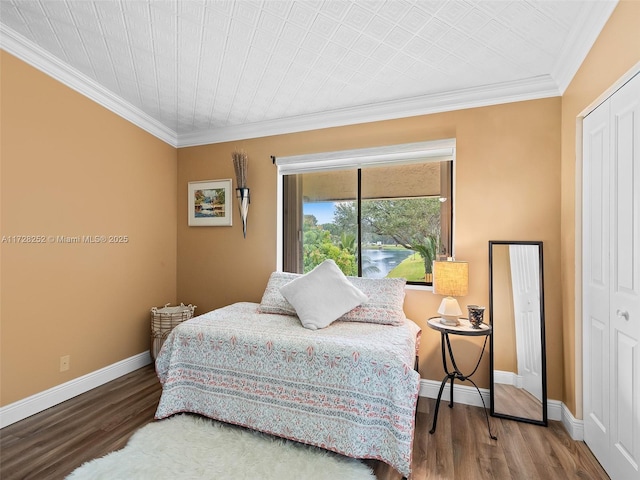 bedroom with a closet, crown molding, and wood-type flooring