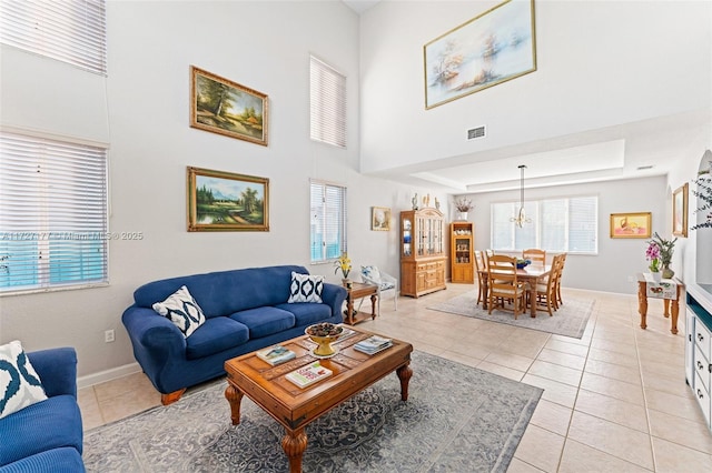 living room with light tile patterned floors and a raised ceiling