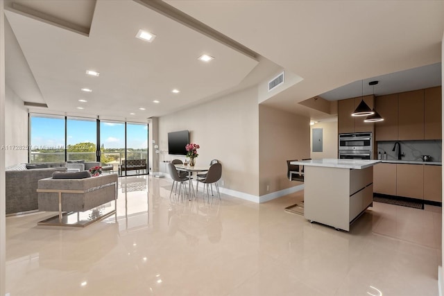 kitchen with light tile patterned floors, floor to ceiling windows, decorative backsplash, a kitchen island, and pendant lighting