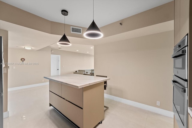 kitchen with a kitchen island, pendant lighting, light tile patterned floors, stainless steel double oven, and light stone counters