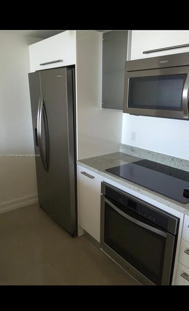 kitchen featuring light stone countertops, white cabinetry, and stainless steel appliances