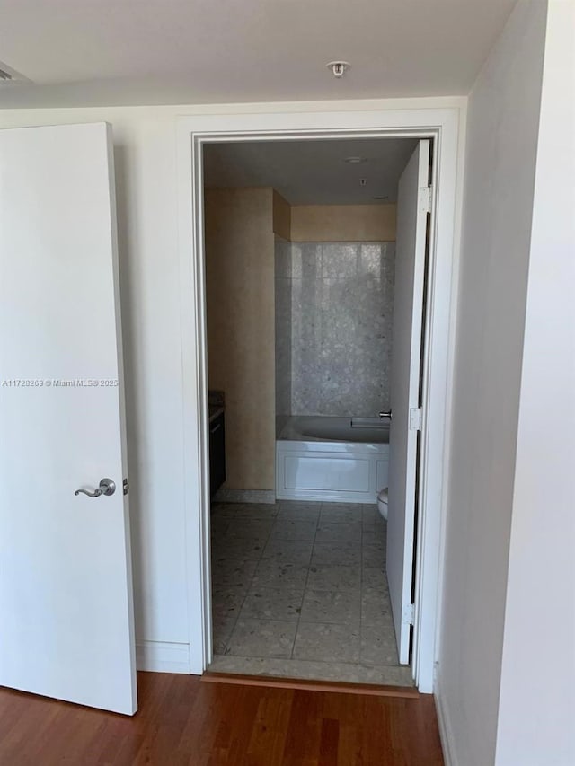 hallway with hardwood / wood-style flooring