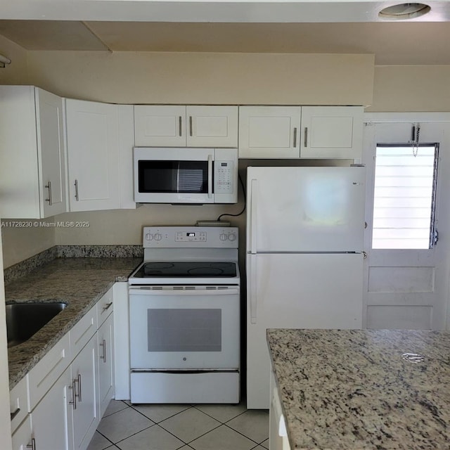 kitchen featuring white cabinetry, sink, white appliances, and light tile patterned flooring