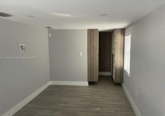 unfurnished room featuring dark wood-type flooring