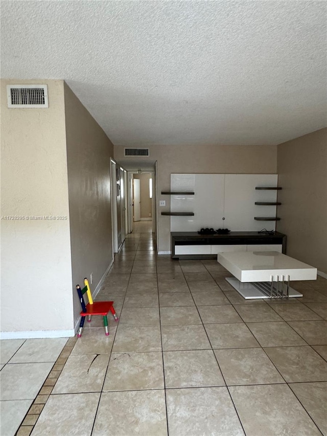 hallway with tile patterned floors and a textured ceiling