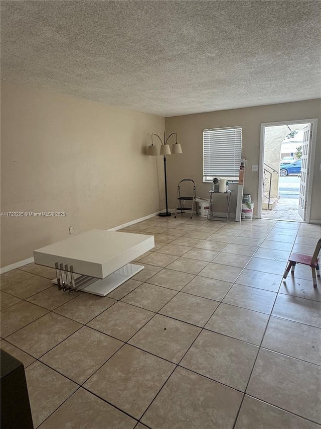 interior space featuring light tile patterned floors and a textured ceiling