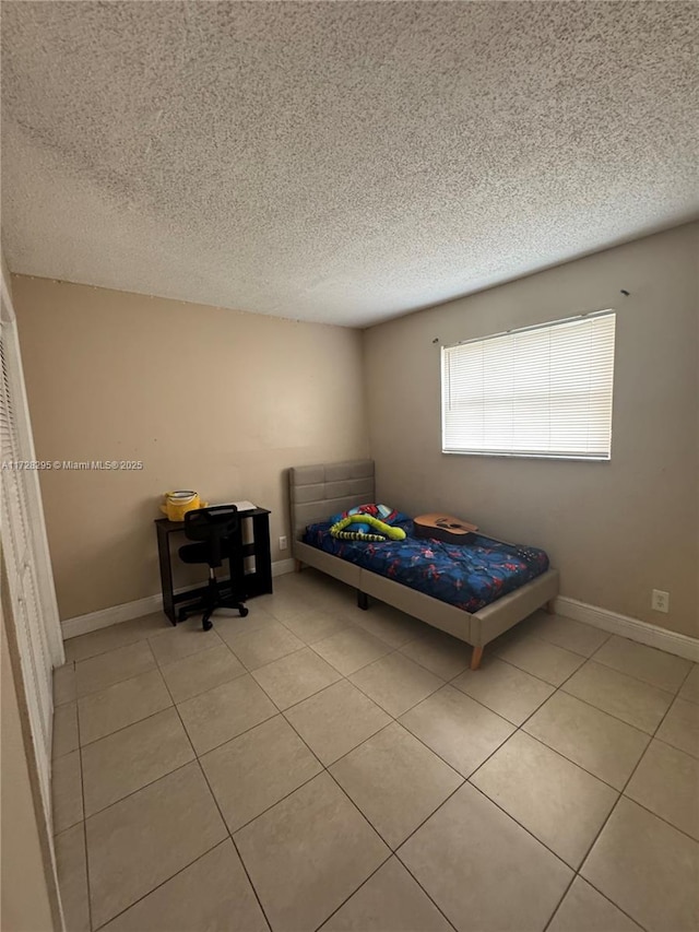 tiled bedroom featuring a textured ceiling