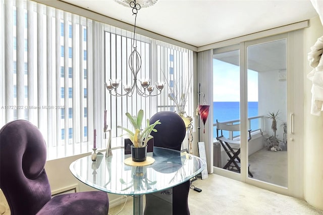 dining space featuring a water view and light colored carpet