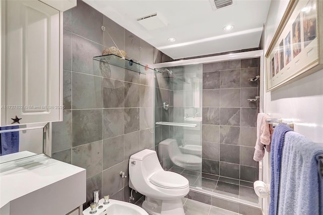 bathroom with a bidet, a stall shower, toilet, and tile walls