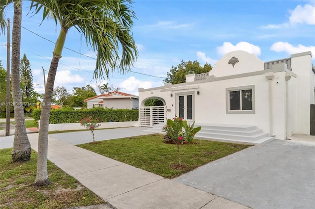 view of front of property featuring a front yard and french doors