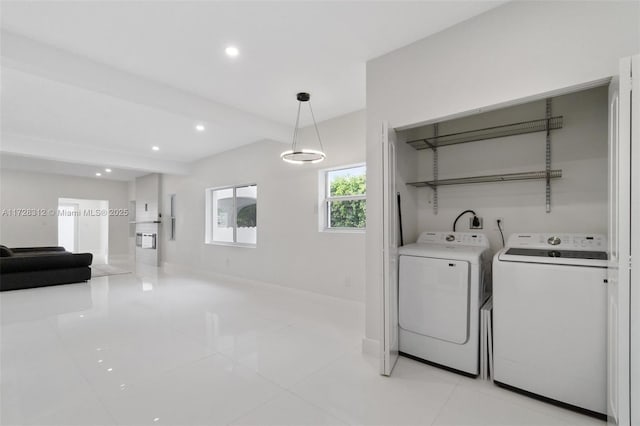 clothes washing area featuring light tile patterned floors and washer and clothes dryer