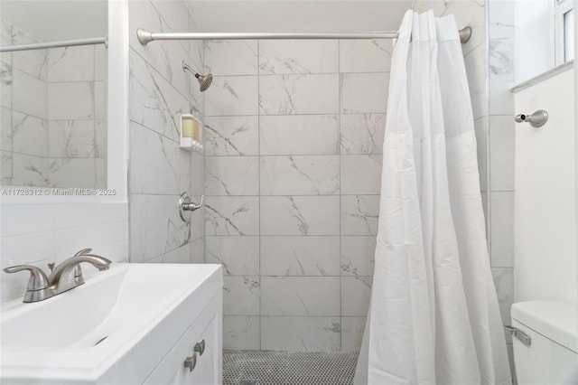 bathroom with toilet, sink, and curtained shower