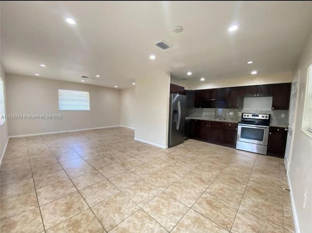 kitchen featuring light tile patterned floors, appliances with stainless steel finishes, dark brown cabinets, and backsplash