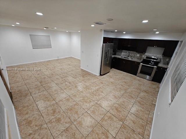 kitchen with light tile patterned floors, backsplash, sink, and stainless steel appliances