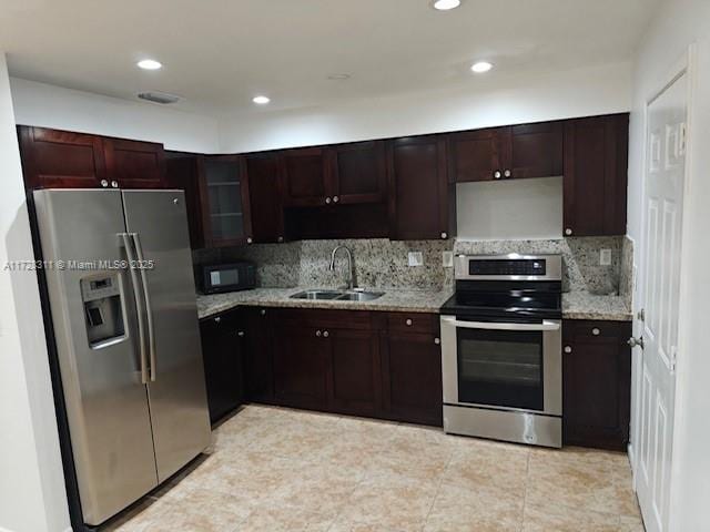 kitchen featuring backsplash, sink, stainless steel appliances, light tile patterned floors, and light stone counters