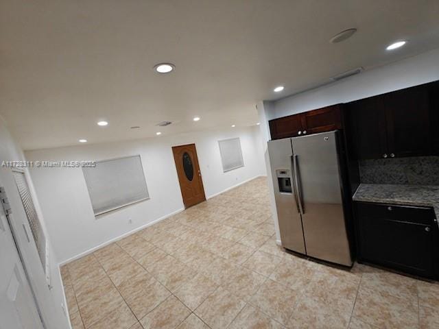 kitchen with stainless steel refrigerator with ice dispenser and stone countertops