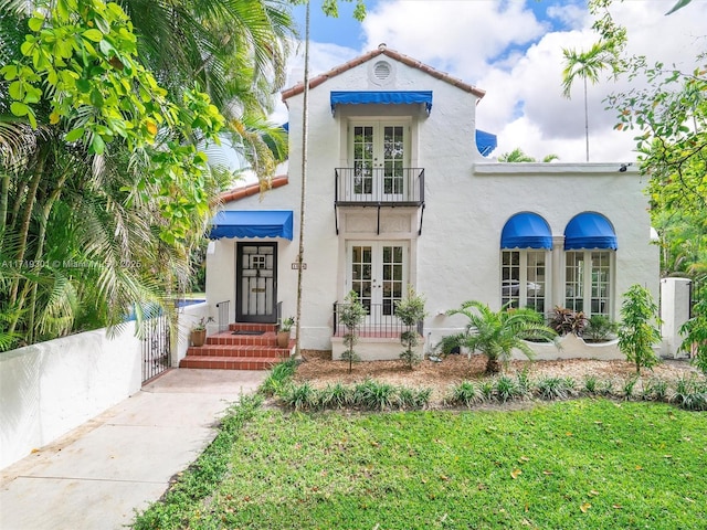 mediterranean / spanish-style home with a balcony and french doors