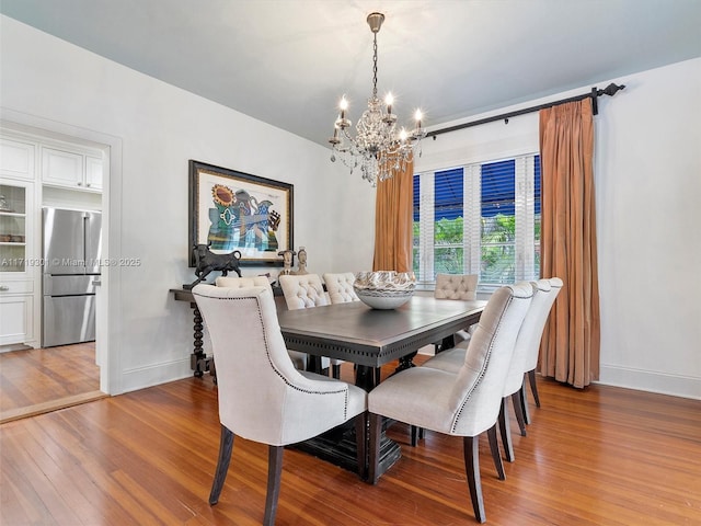 dining space with hardwood / wood-style floors and a chandelier