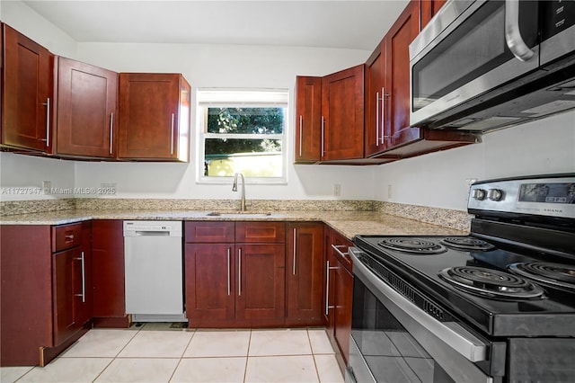 kitchen featuring light tile patterned floors, sink, light stone counters, and appliances with stainless steel finishes