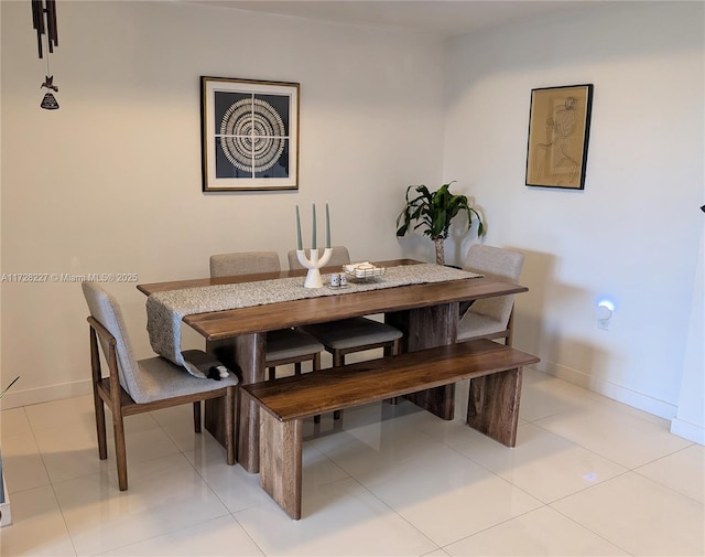 dining area featuring light tile patterned floors and baseboards