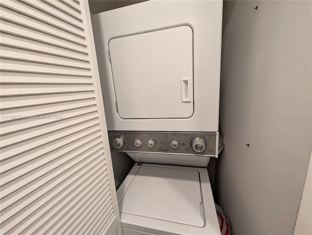 clothes washing area featuring stacked washing maching and dryer