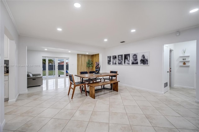 tiled dining space featuring crown molding and french doors