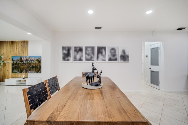 dining space featuring light tile patterned flooring and crown molding