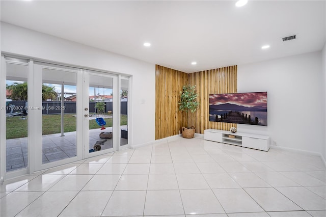 tiled living room featuring french doors and wooden walls