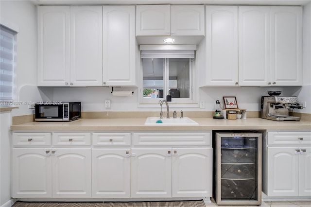 kitchen with sink, white cabinets, and wine cooler