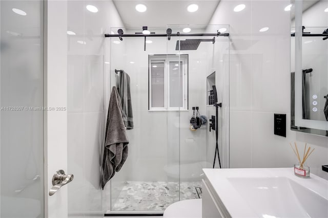 bathroom with tile walls, an enclosed shower, vanity, and toilet