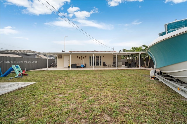 back of property with a yard and a patio