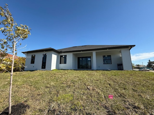 rear view of property featuring a lawn