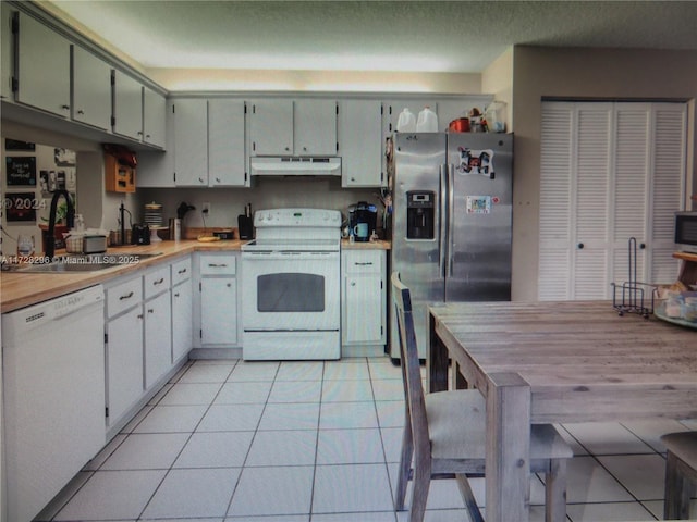 kitchen featuring sink, white appliances, and light tile patterned flooring